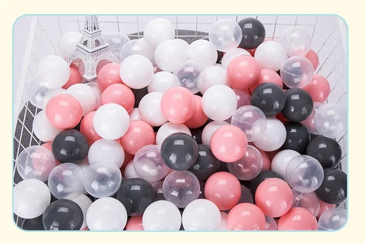 A large plastic container filled with a variety of colorful, clear, and opaque balls for play.