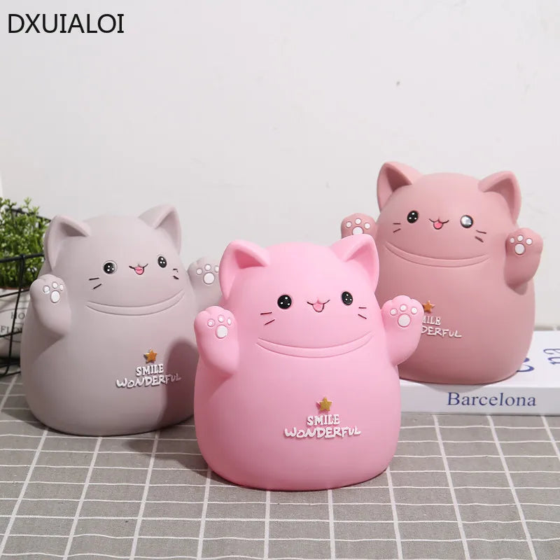 Two pink cartoon cat piggy banks with a smile design placed on a white surface.