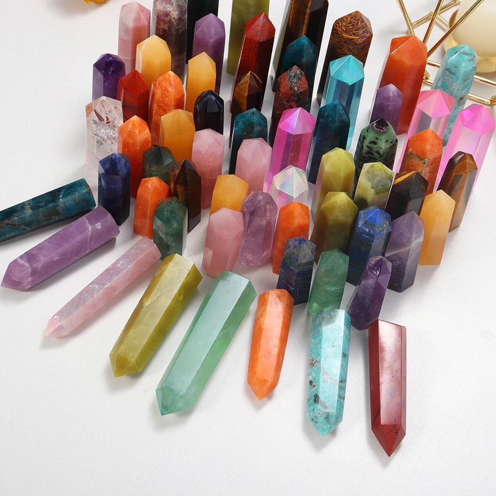 A collection of natural crystal point prisms in various colors and shapes arranged on a white background.