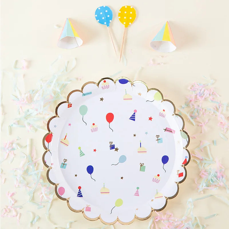 A white paper plate decorated with colorful dots, stars, and small paper party items on a light background.