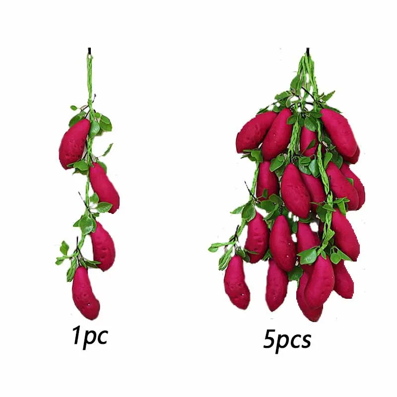 A display of five bright magenta artificial fruits or vegetables hanging on green vines.