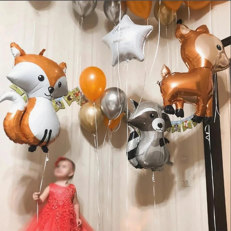 A set of woodland animal foil balloons, including a fox and a deer, hanging against a white background.