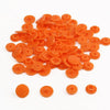 A pile of assorted orange snap buttons in various sizes for crafting.