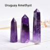 Three deep purple Uruguay Amethyst crystal points displayed on a white surface.