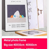 A set of metal photo frames in various sizes displayed on a light surface.
