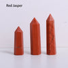 A set of three red jasper crystal point prisms or towers displayed on a white surface.