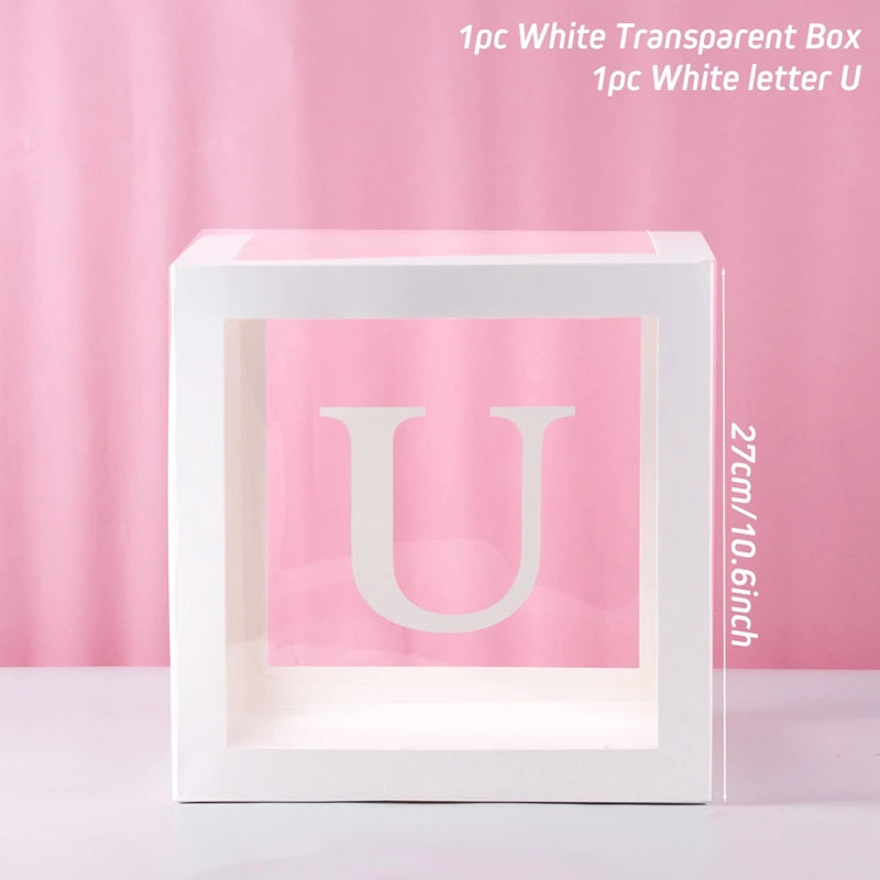 A white transparent box containing a white letter U for birthday or baby shower decorations.
