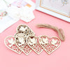 A set of ten wooden heart-shaped hanging ornaments featuring engraved birds on a pink background.