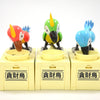 Three plastic parrot figures in various colors standing on yellow boxes labeled with the Chinese characters for money bank