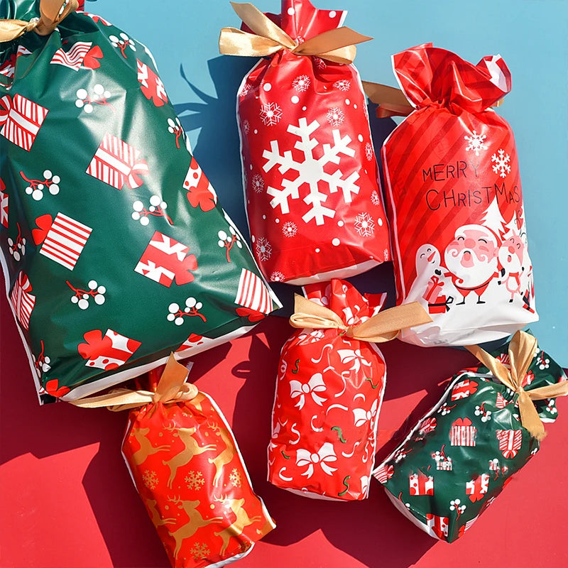 A collection of festive red and green drawstring gift bags decorated with snowflake and Santa designs.