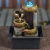 A tabletop water fountain featuring a glass orb, flowing water, and natural stone elements.
