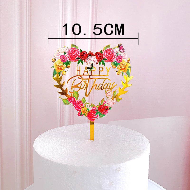 Rose gold acrylic happy birthday cake topper featuring colorful roses and greenery on a white cake.