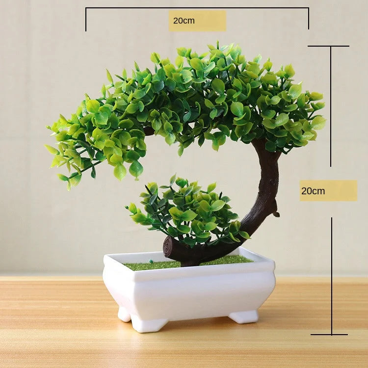 Artificial bonsai tree with bright green leaves displayed in a white pot on a wooden surface.