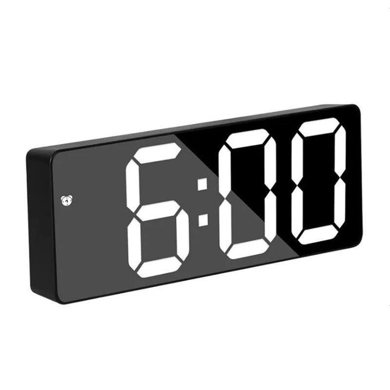 A black digital alarm clock displaying the time 6:00 on a white background.