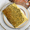 Gold pearl laser cut wedding invitations folded in a yellow envelope on a white plate