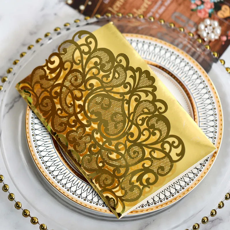 Gold pearl laser cut wedding invitations folded in a yellow envelope on a white plate
