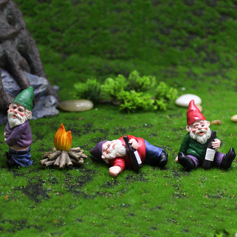 A collection of miniature resin gnome statues with beards and hats lying on green grass in a garden setting.