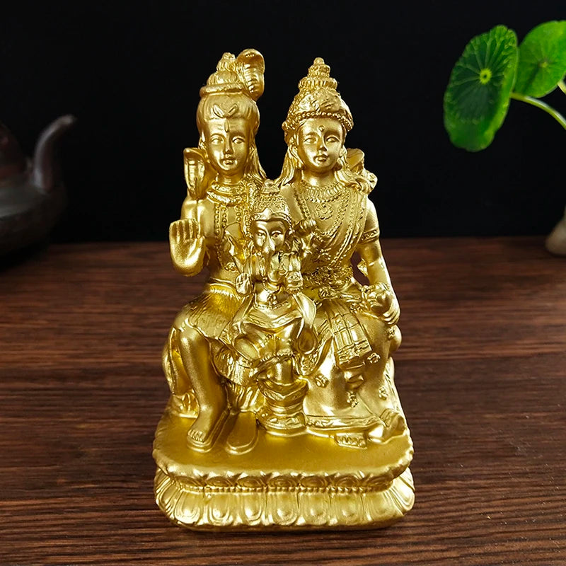 Gold-colored resin figurine of a Hindu or Buddhist deity with a child seated on its lap