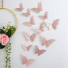 Ein Set aus rosa und weißen 3D-Hohl-Schmetterlings-Wandaufklebern, aufgehängt an einem goldenen Ring.
