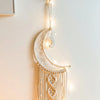Boho macrame dream catcher wall decor featuring a crescent moon hanging on a light-colored macrame piece.