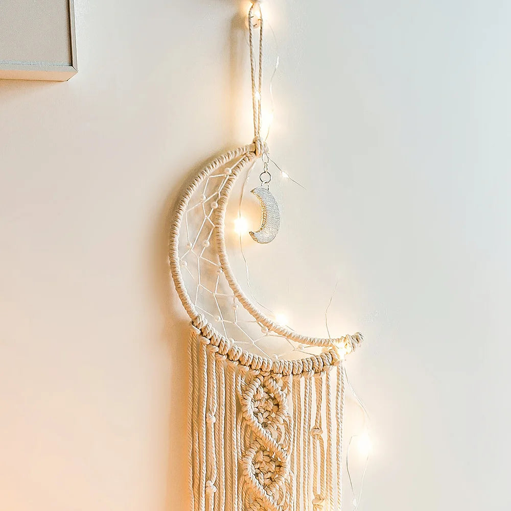 Boho macrame dream catcher wall decor featuring a crescent moon hanging on a light-colored macrame piece.