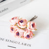 Eine Ansammlung rosa und lila Kunstseidenrosen als Girlande für Hochzeiten und Home-Dekoration.
