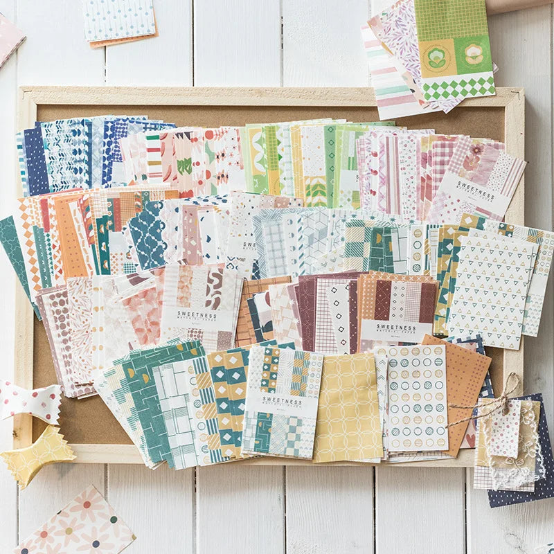 A collection of decorative memo pads and cards in various patterns and colors arranged on a wooden frame.