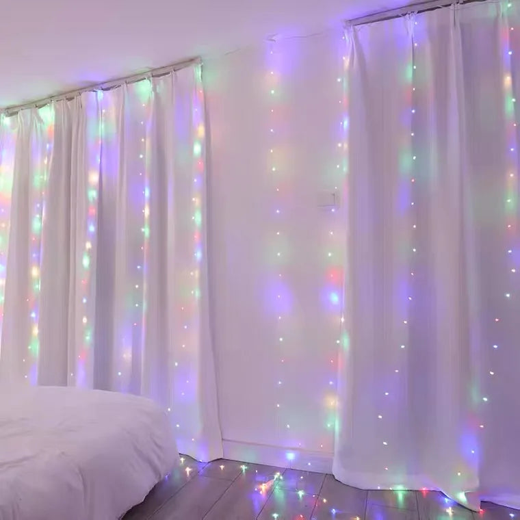 White sheer curtains illuminated by warm white LED string lights in a room setting
