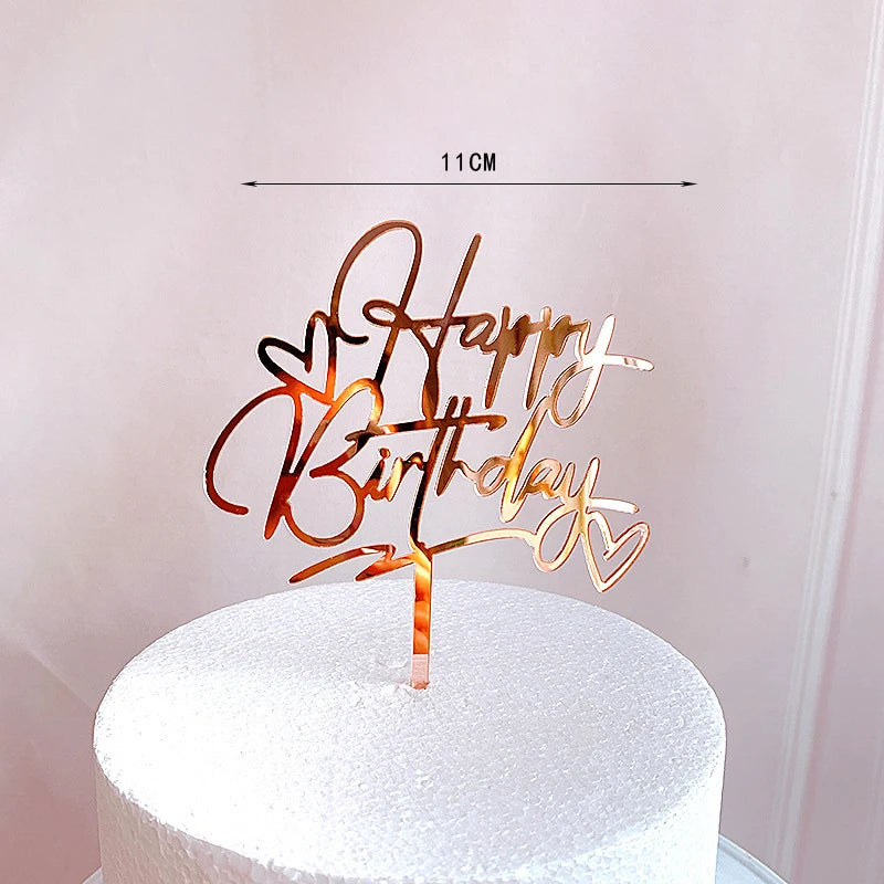 Rose gold acrylic happy birthday cake topper on a white cake.