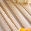 Elegant chiffon fabric draped in soft beige folds with white roses and yellow accents.