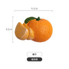 A realistic orange fruit with a green stem, used as a fridge magnet.