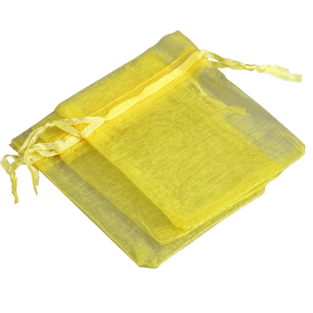 Yellow organza drawstring gift pouches stacked together.