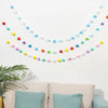 A colorful felt ball garland featuring various pastel and bright colored balls strung together for home decor.