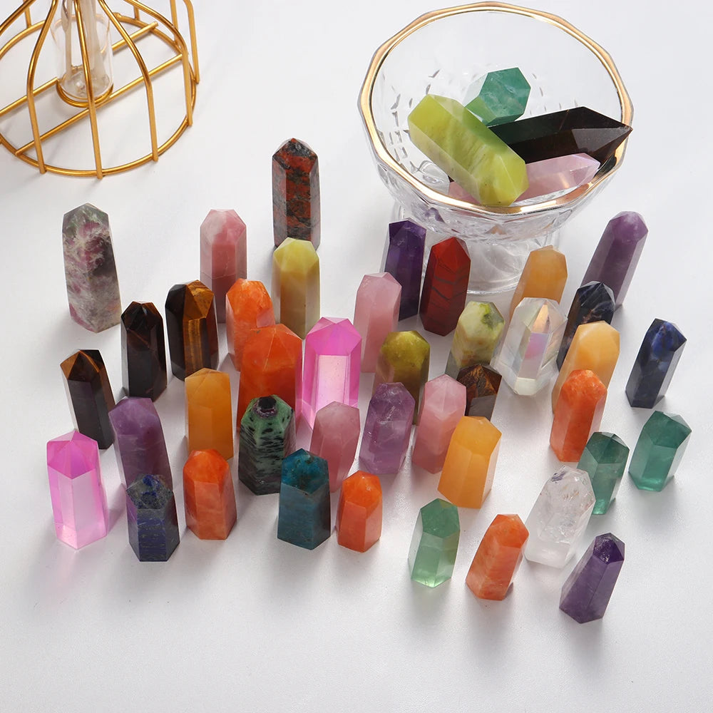 A collection of colorful natural crystal points and prisms arranged on a white surface.