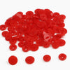 A pile of assorted red snap buttons in various sizes for crafting.