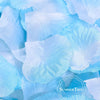 A close-up of light blue silk rose petals scattered on a surface.