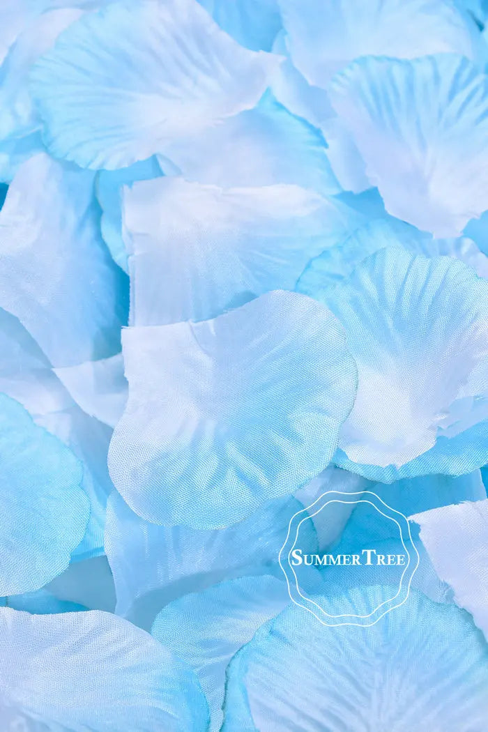 A close-up of light blue silk rose petals scattered on a surface.