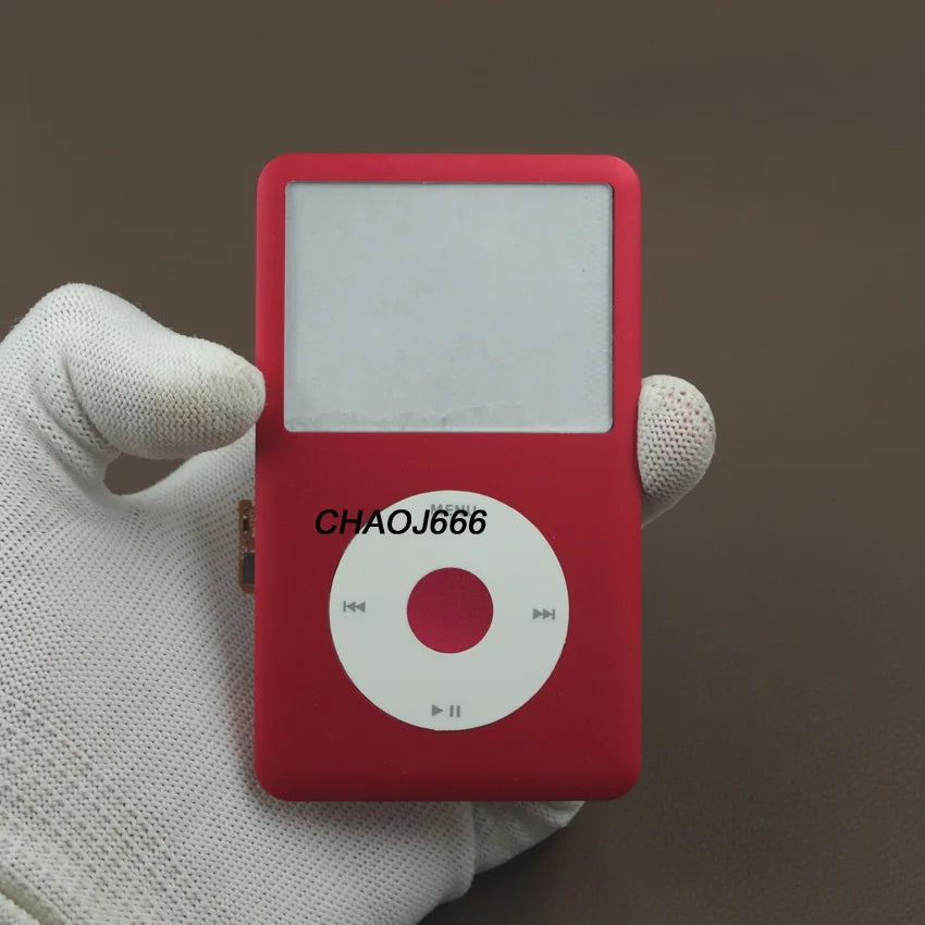 Une main tient un appareil électronique rouge avec une face blanche et une interface bouton circulaire.
