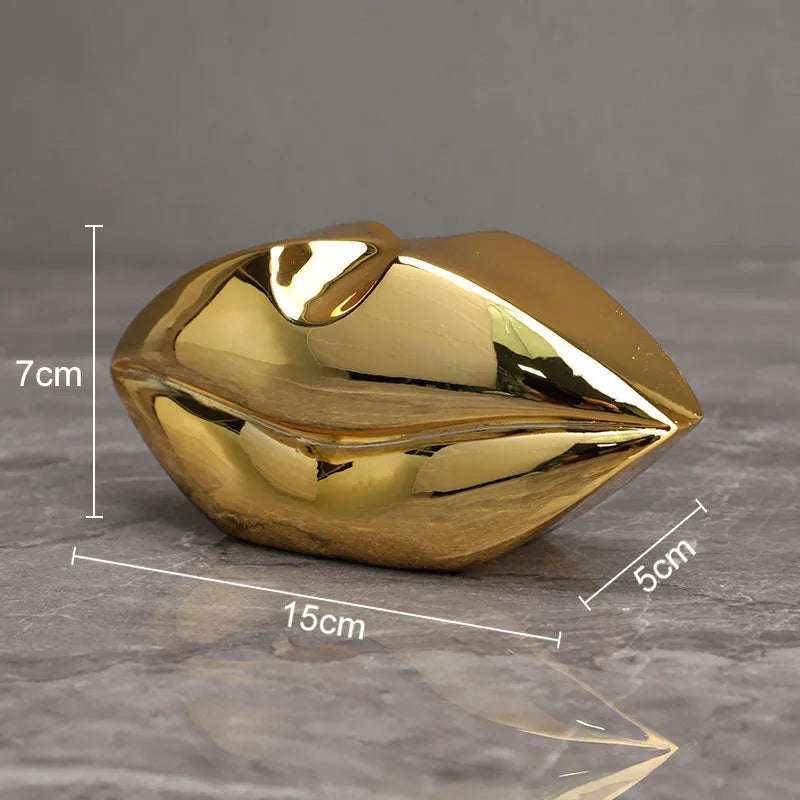 A golden, leaf-shaped resin art sculpture with a faux finish, shown on a gray surface.