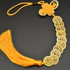 A necklace featuring an I Ching copper coin charm with a handwoven knot and orange thread.