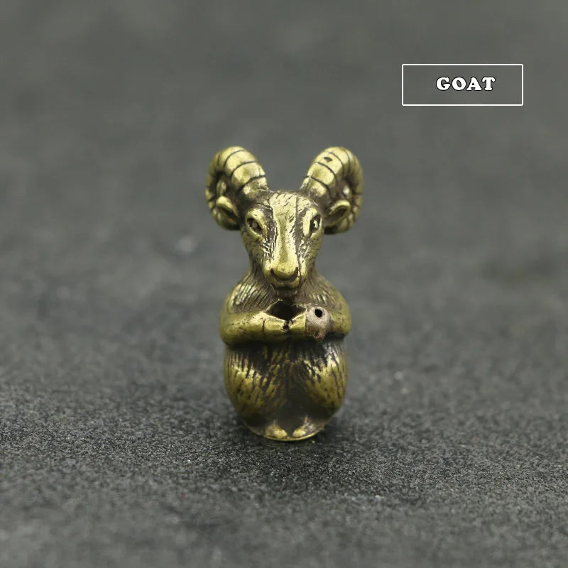 A small brass statue of a goat with horns, sitting on a dark gray surface.