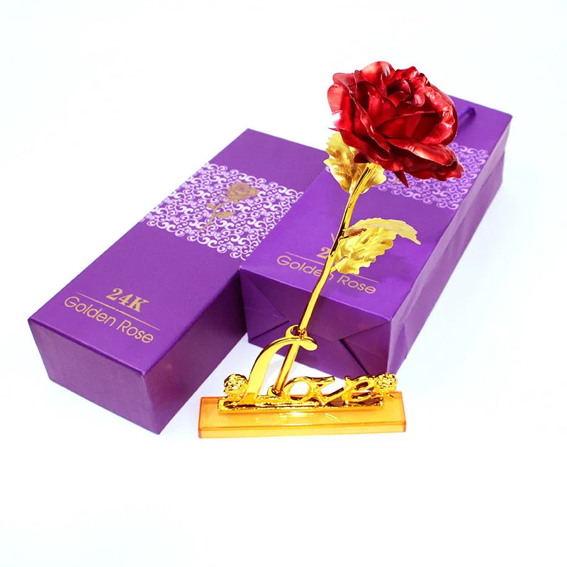 A purple box containing a 24K gold foil artificial rose with a red rose and gold leaves.