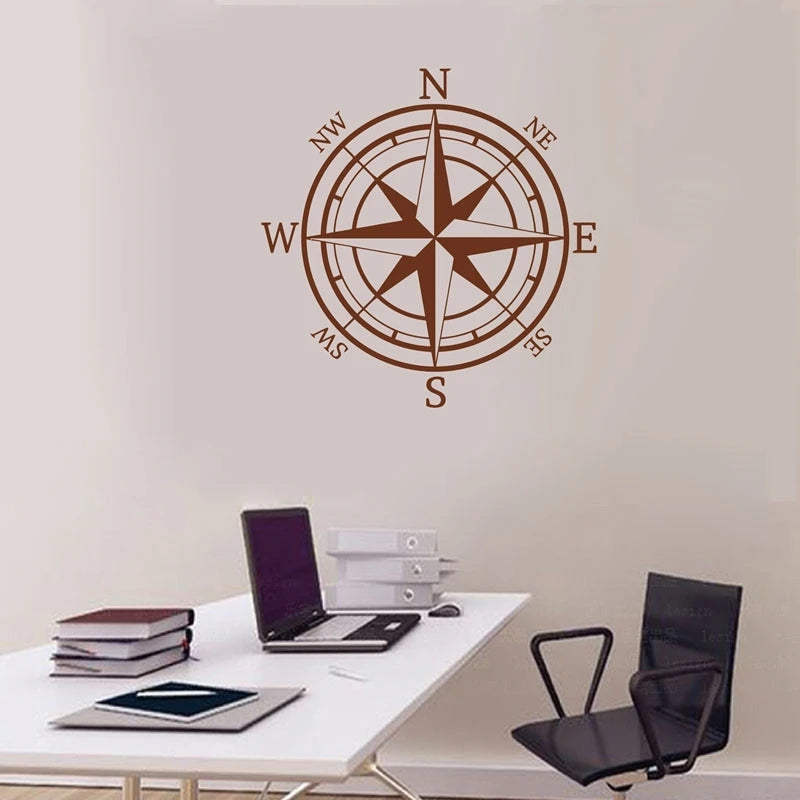 A brown nautical compass rose wall decal is displayed on a white desk.