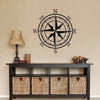 A black nautical compass rose wall decal is displayed above a dark wooden cabinet.