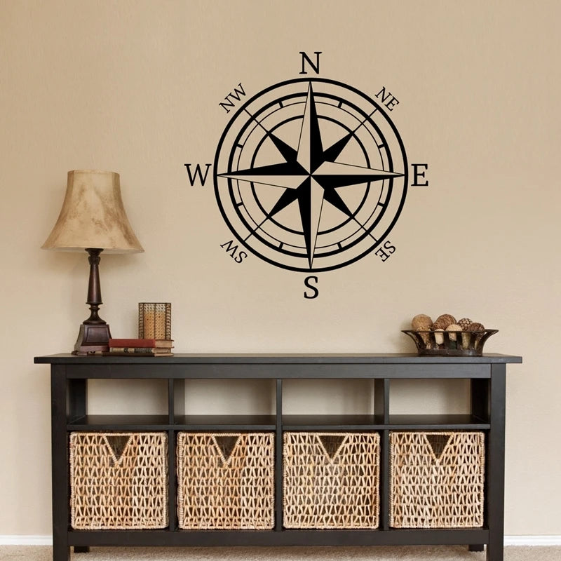 A black nautical compass rose wall decal is displayed above a dark wooden cabinet.