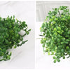 A cluster of vibrant green artificial fern and leaf sprigs for home decor