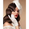 A woman wearing white lace gloves and a sheer white fascinator for a vintage look.