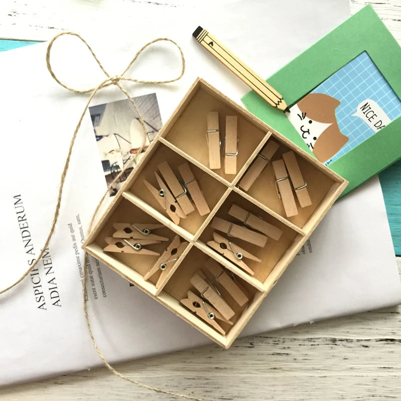 A wooden box filled with natural wooden clips for crafts, photos, and decor, resting on a white surface.
