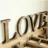 A collection of vintage wooden alphabet letters spelling LOVE used for home decor or events.