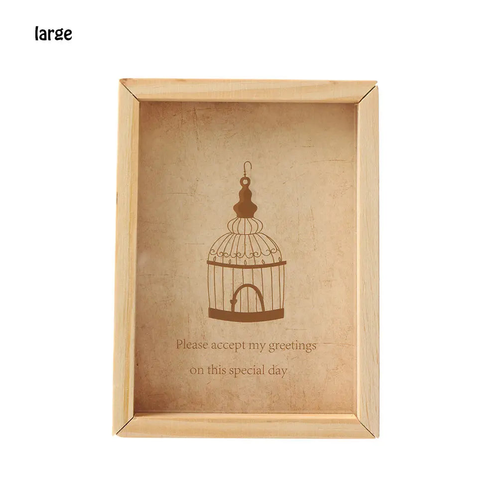 A light wood photo frame with a decorative birdcage silhouette etched into the glass.